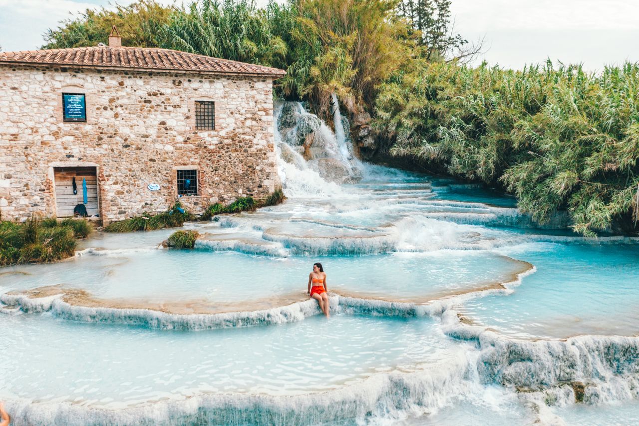 Eine Frau entspannt sich in den malerischen Cascate del Mulino Thermalquellen in der Toskana, Italien.