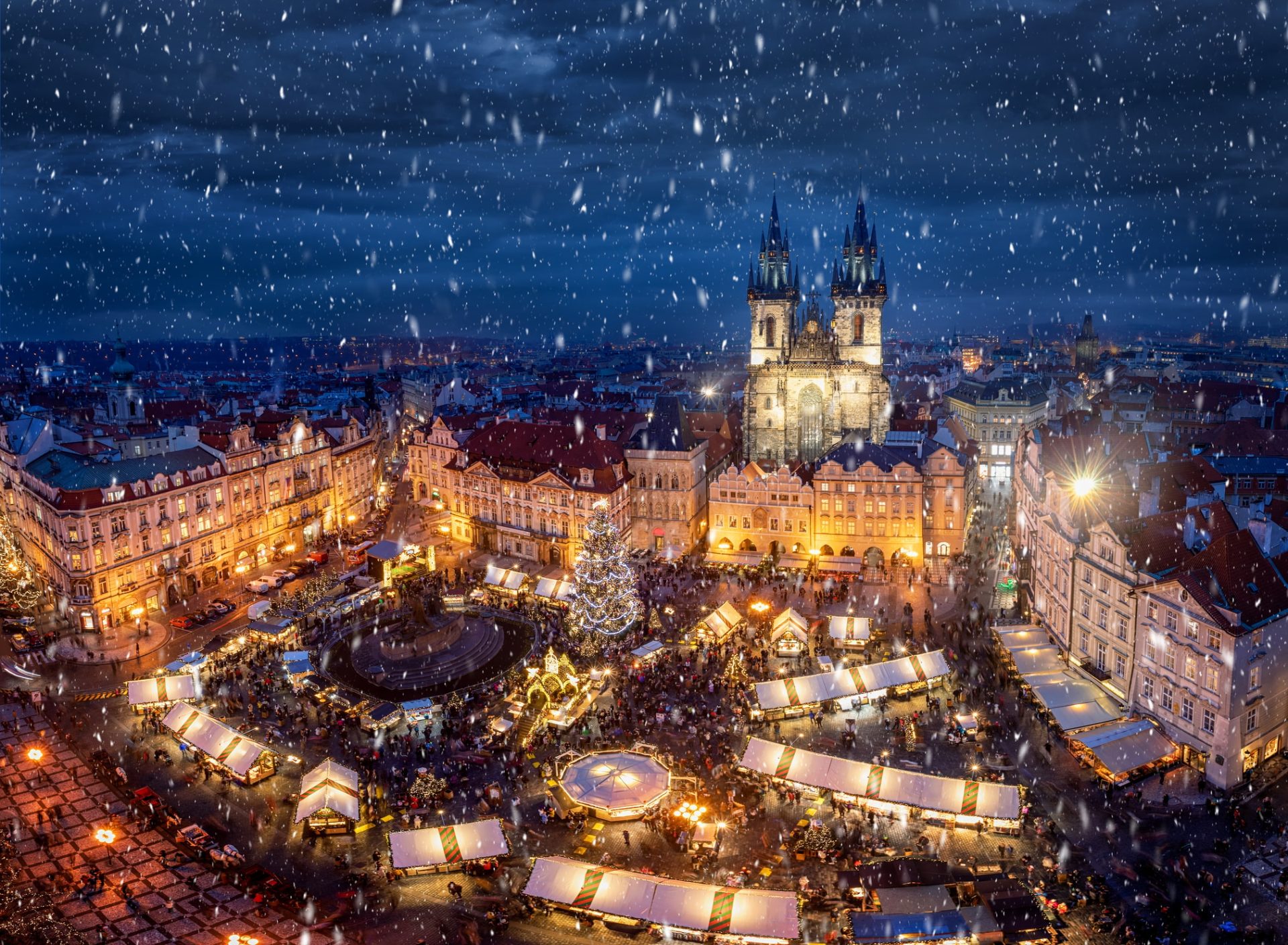 Weihnachtsmarkt in Prag: Blick auf den Altstadtplatz von Prag mit dem traditionellen Weihnachtsmarkt und Schneefall