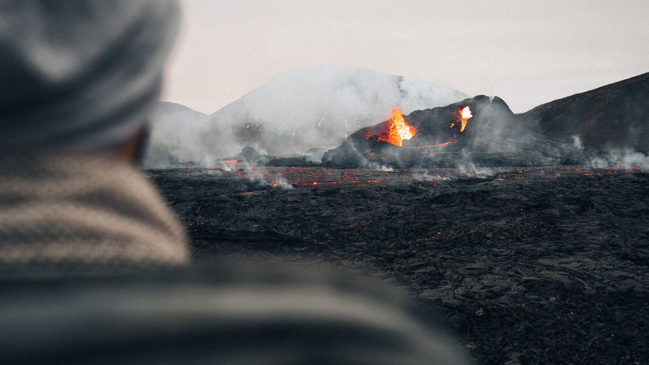 Eine eindrucksvolle Aussicht auf einen Vulkanausbruch in Island mit glühender Lava und Rauch.